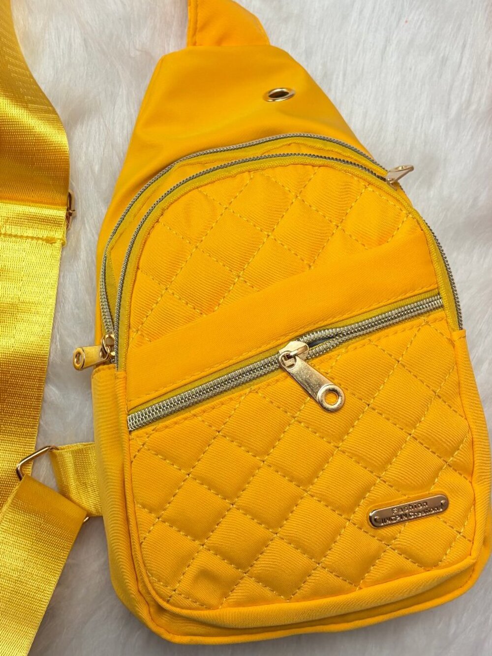 Yellow quilted crossbody sling bag featuring a diamond-stitched front, gold-tone